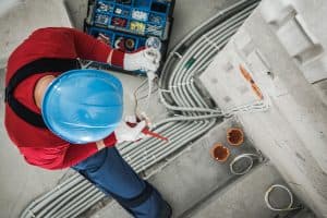 Electrician checking wires of a light fixture.